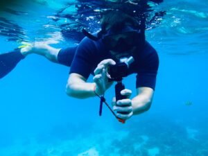 Male snorkeler using action camera underwater